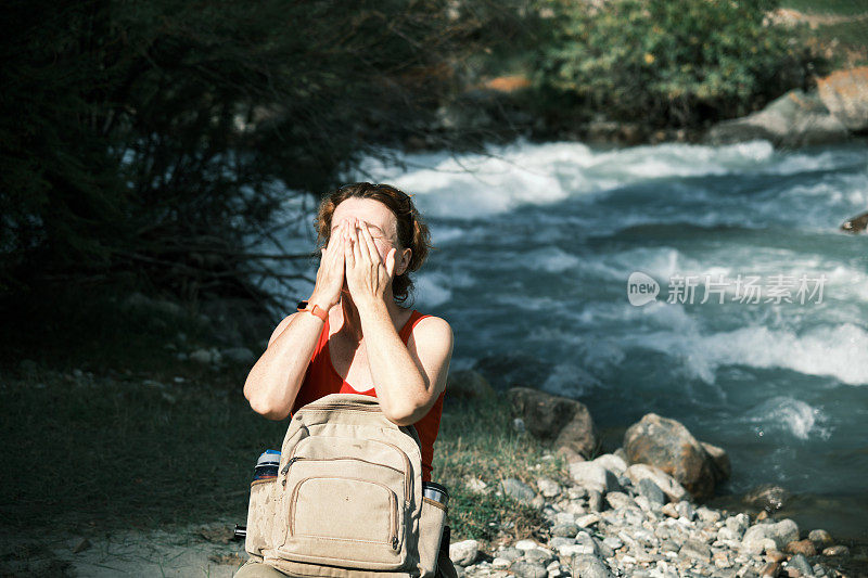 女游客在山河中洗手洗脸
