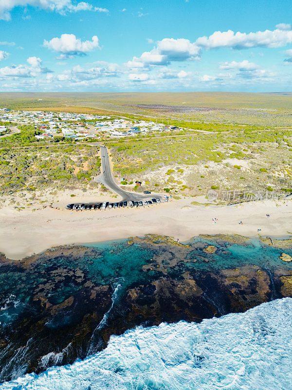 鸟瞰在澳大利亚卡尔巴里的蓝洞，汽车停在沙滩上，迎着海浪
