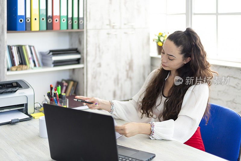 一位年轻女性，律师或银行职员，在她的工作场所。