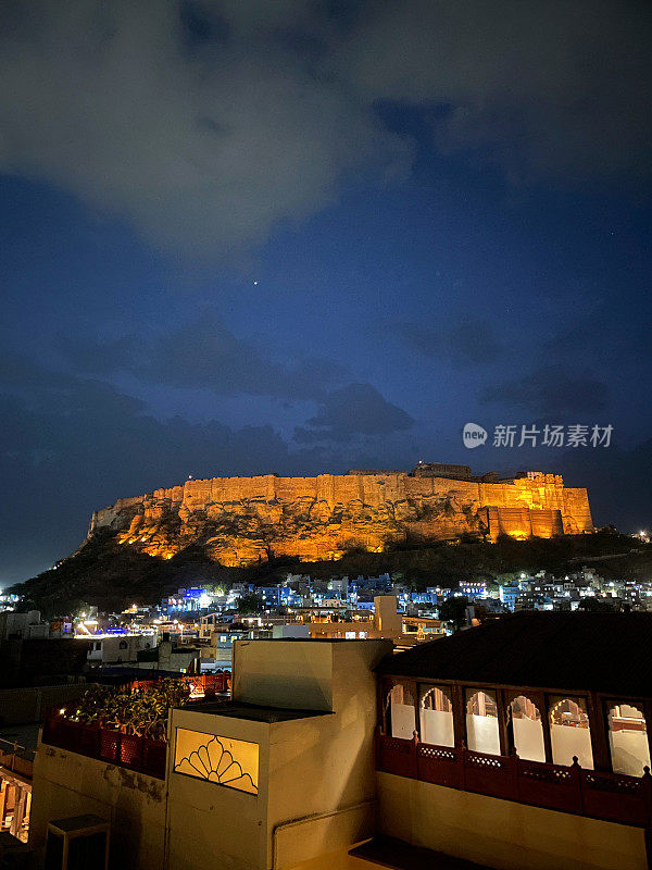 印度拉贾斯坦邦焦特布尔老城区和Mehrangarh堡的屋顶视图，蓝色城市的建筑物和建筑，照亮的黄昏视图，聚焦于前景