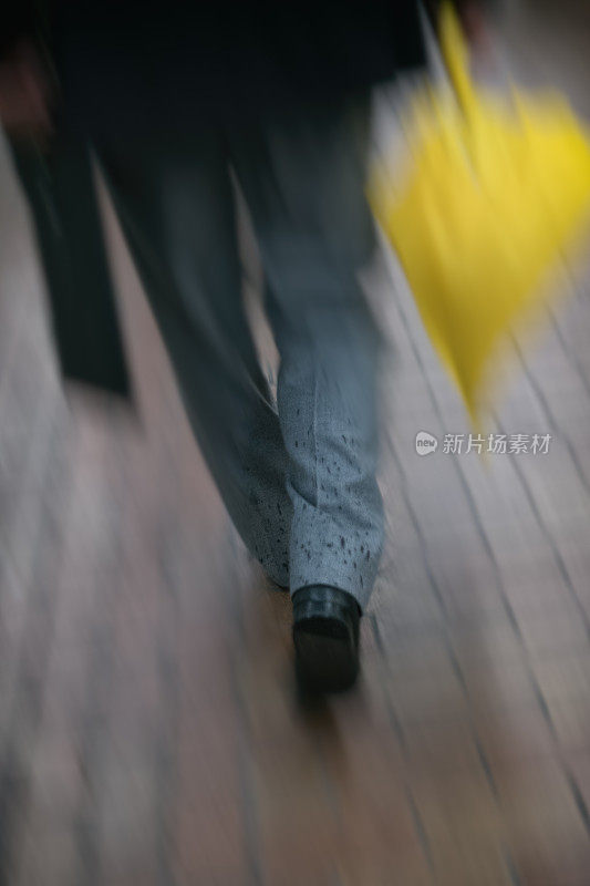 一个男人在下雨天迅速走开的画面