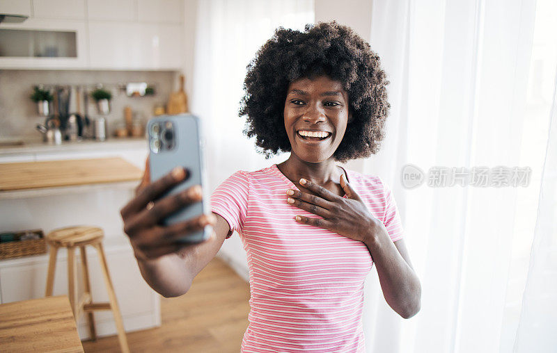 微笑的年轻女子正在用她的手机进行视频通话