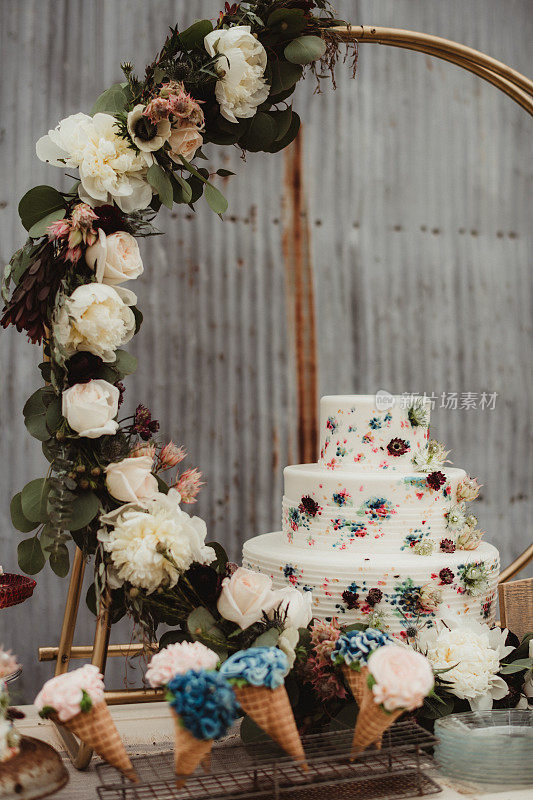 婚礼蛋糕和纸杯蛋糕放在甜点桌上的冰淇淋甜筒里