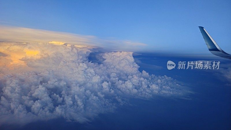 透过窗户看飞机在飞行过程中的机翼与一个漂亮的蓝天白云。