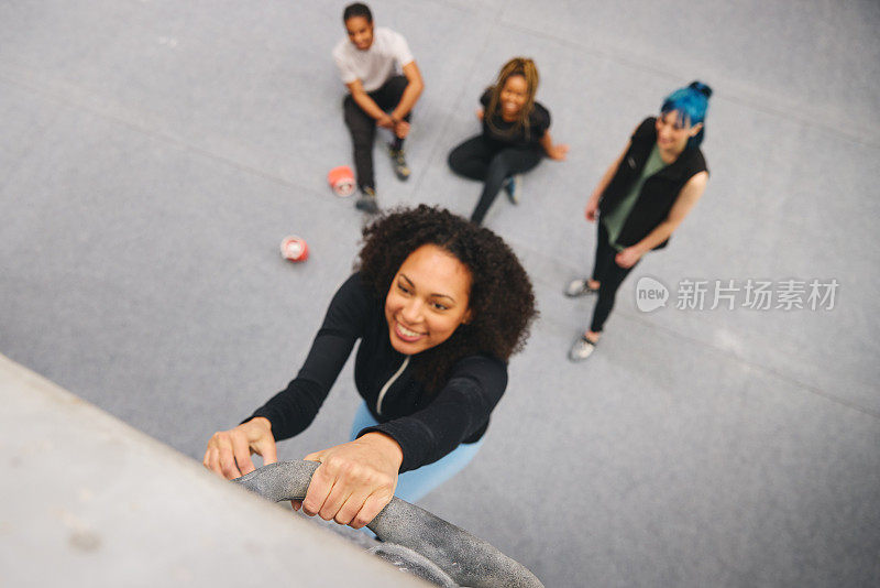多文化团体与教练在室内活动中心看朋友攀岩
