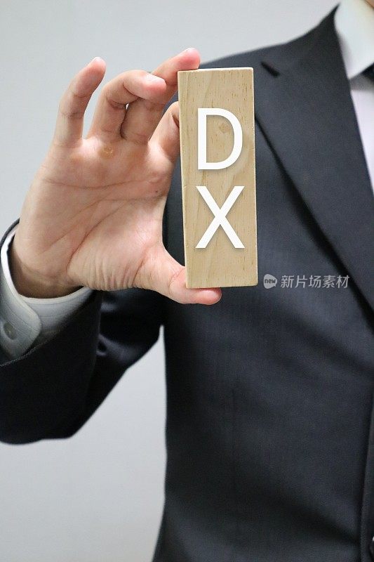 一个人拿着一块写着DX的块