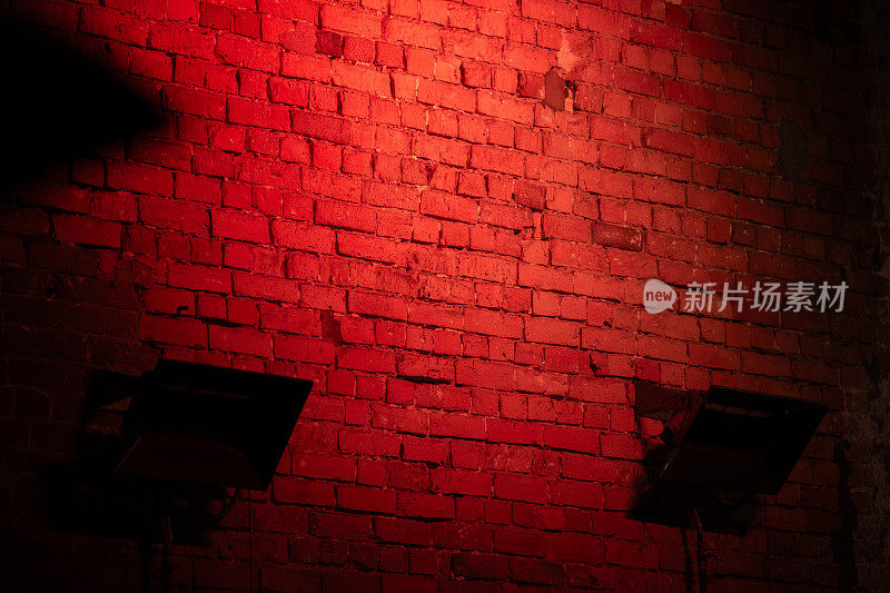 被红色霓虹灯照亮的深色砖墙