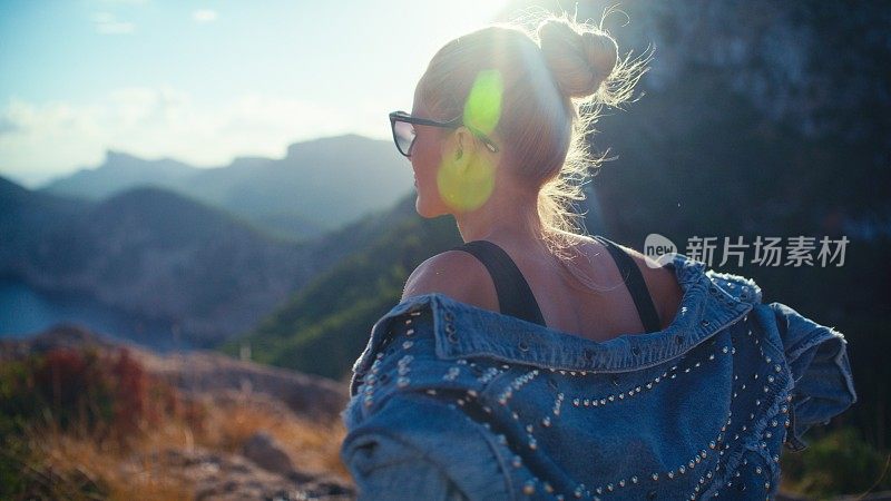 在山上徒步旅行的女游客。在炎热的暑假里欣赏风景