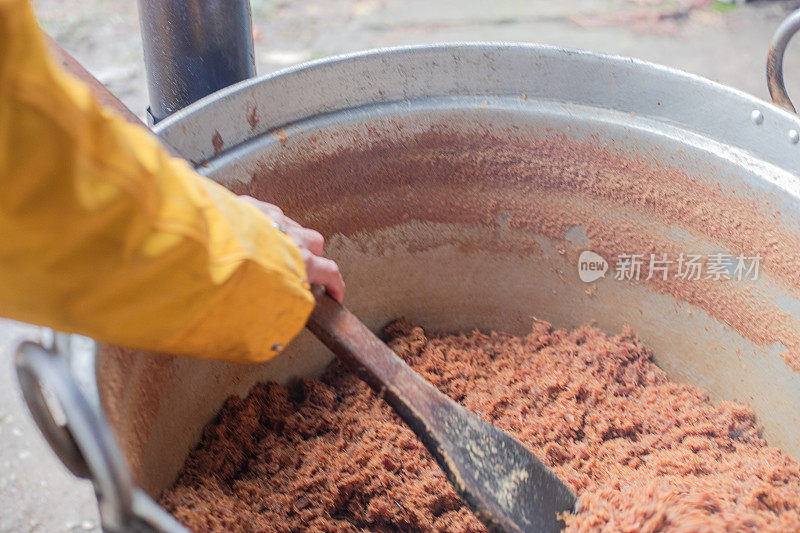 厨师在大锅里煮猪油，这是传统的烹饪方法