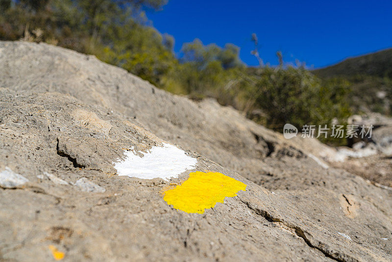 画在岩石上的黄色和白色的条纹线，是给徒步旅行者的方向标志。