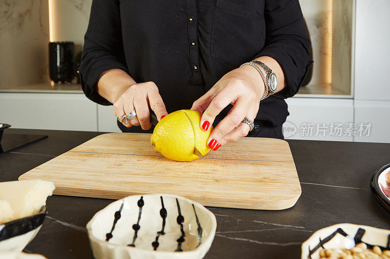 女主人在厨房切柠檬，用大理石做背景