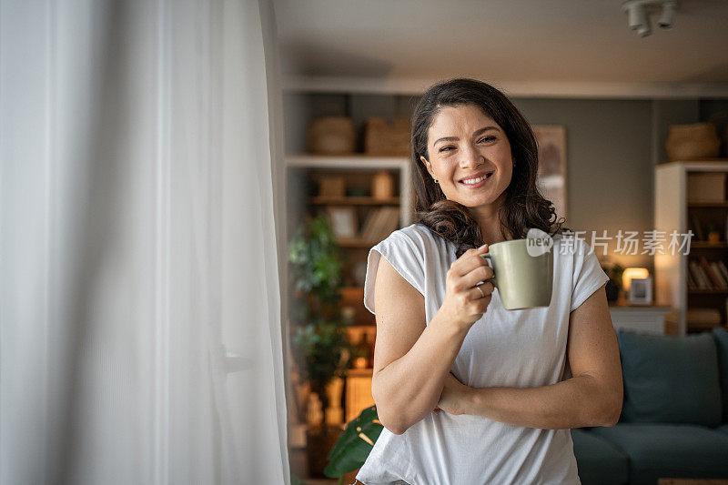 一位年轻女子享受着宁静的早晨，享受着芳香的过滤咖啡