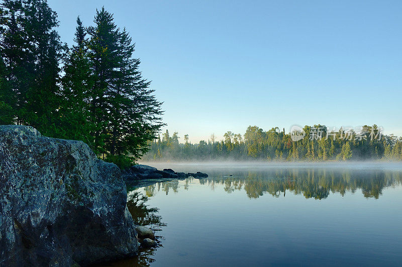 早晨的倒影在一个雾蒙蒙的荒野湖