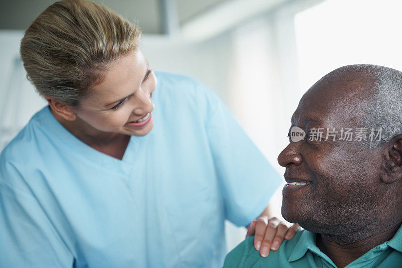 护士将手放在病人肩膀上问候病人