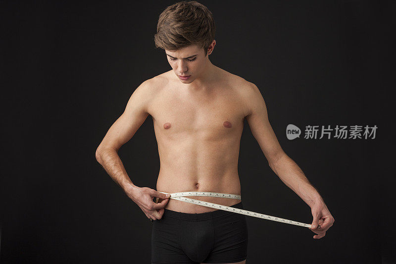 男人在测量他的腹部尺寸