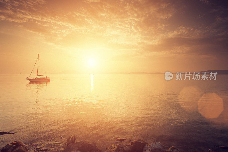 日落时湖面上的帆船。