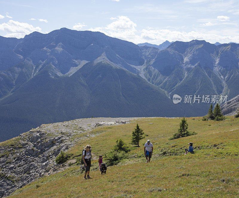 一家人走在高山、山谷的山坡上