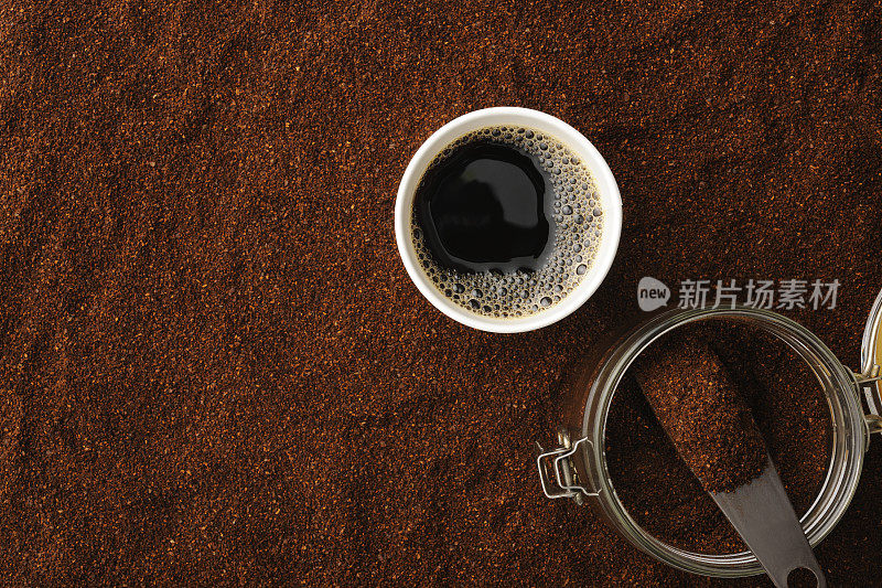 一次性杯子里的黑咖啡，磨碎的咖啡豆