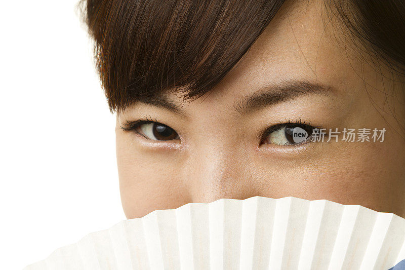 特写的日本妇女覆盖她的脸与纸扇