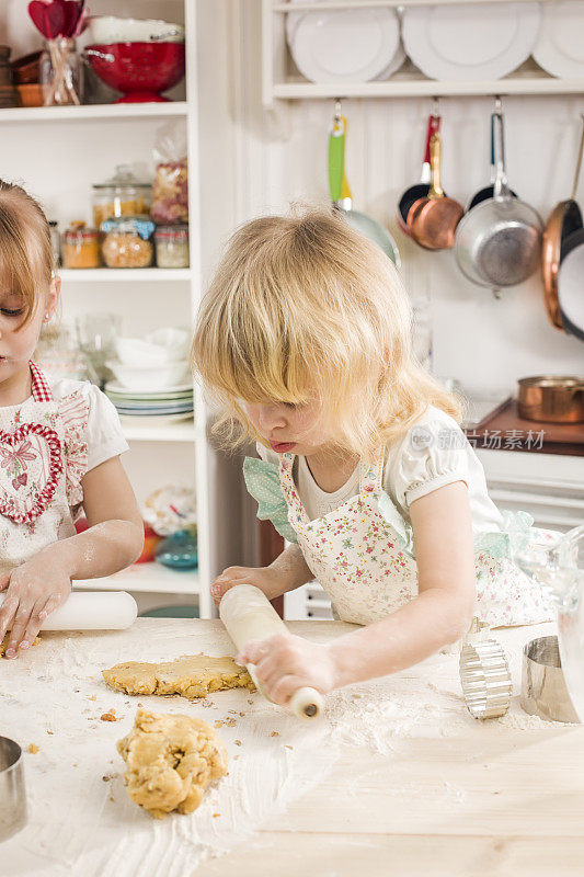 两个小女孩在厨房里准备饼干