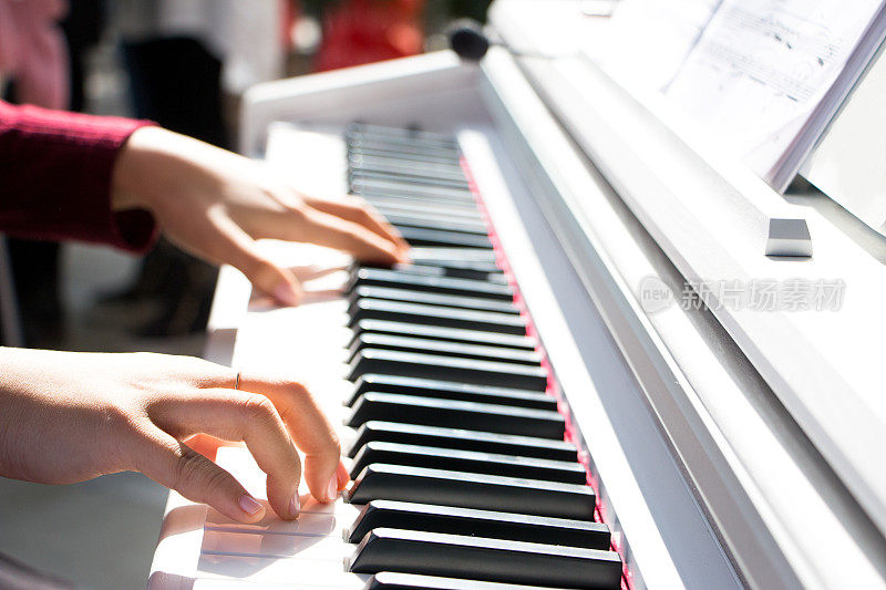 女孩的手放在钢琴键盘上
