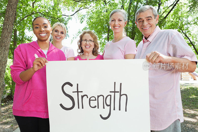 一群乳腺癌幸存者和支持者举着“力量”的牌子