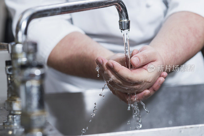 餐馆里的工人在厨房水槽里洗手