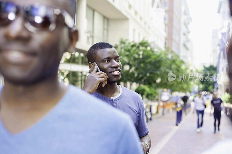 年轻的非洲人微笑着，他讲电话