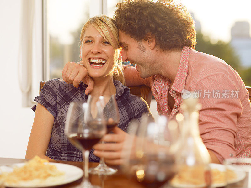相爱的年轻情侣在享受美酒和意大利面