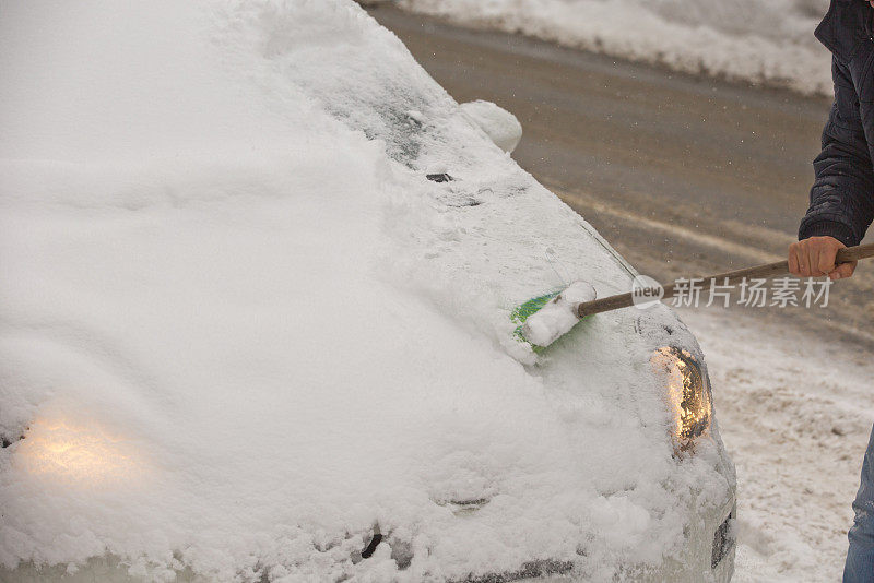 一个男人清理车上的雪的特写