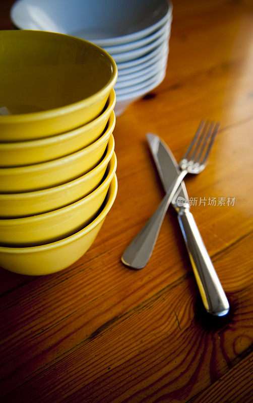 厨房桌子上堆放着银餐具的碗。
