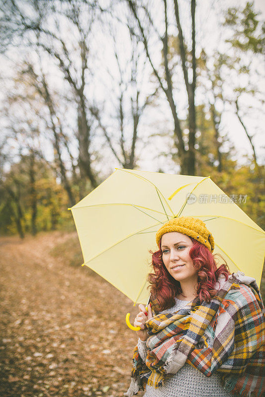 拿着黄伞的女人微笑着