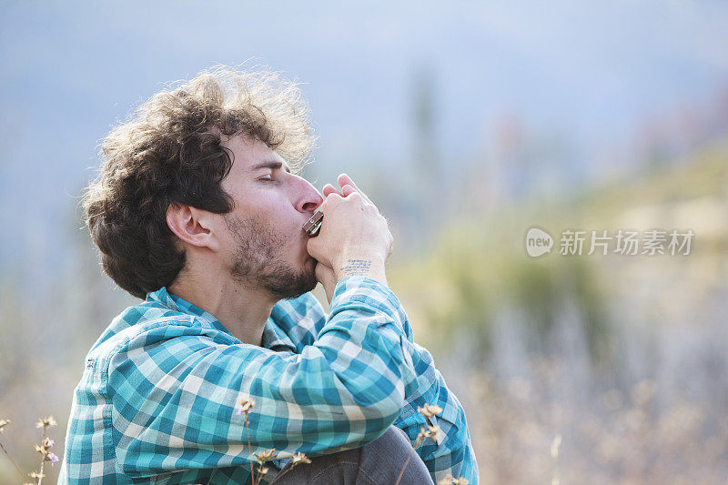 年轻人，游客，徒步旅行者和潮人，在约塞米蒂国家公园的山上休息和演奏口琴