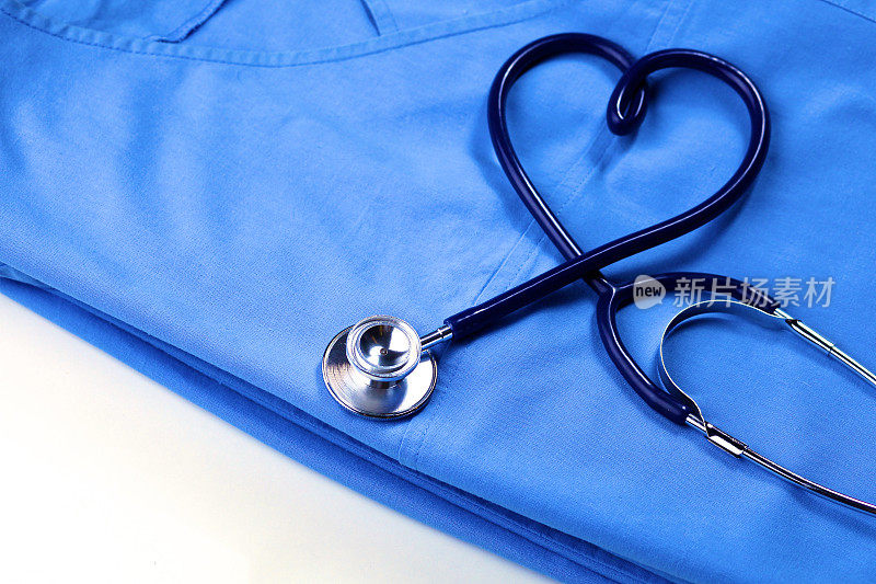 医疗听诊器扭曲在心脏形状躺在病人的医疗历史表和蓝色医生制服特写