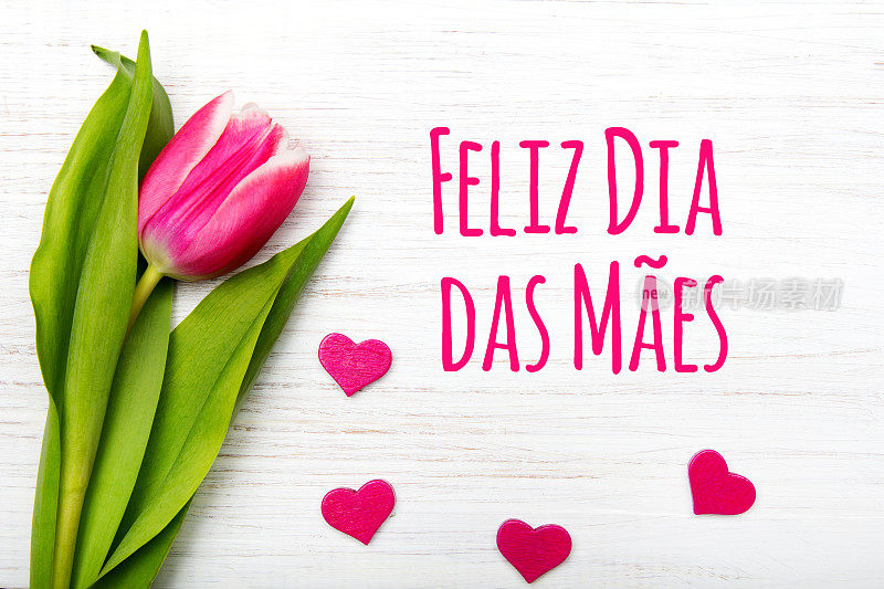 葡萄牙语的母亲节贺卡:母亲节快乐，粉红色的郁金香在白色的木制背景。