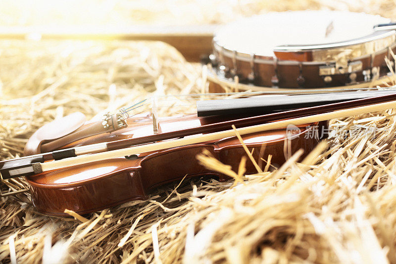 分散的小提琴和班卓琴躺在稻草上