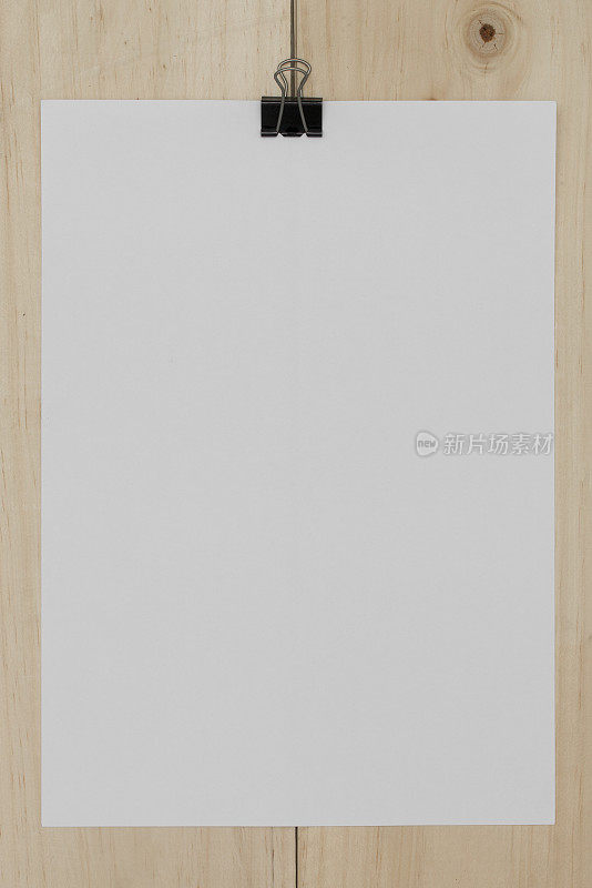 白色的纸与回形针在木制的背景。