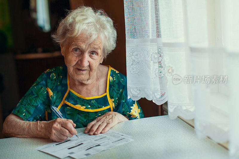 一位老年妇女填写水电费账单。