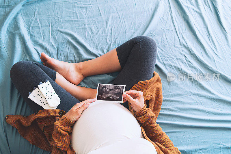 孕妇拿着超声波图像。