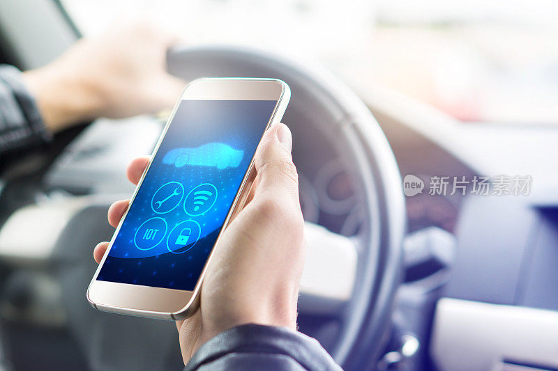 现代汽车用智能手机上的物联网(IOT)移动应用。手持智能手机与未来的ADAS系统。自动控制的车辆。驾驶舱内景。