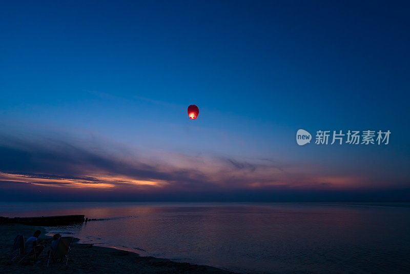夜晚，中国的灯笼在平静的海面上飘扬