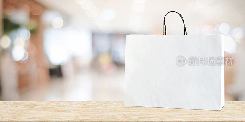 白色购物袋木制桌子上模糊的商店背景，业务，模板，产品展示蒙太奇背景