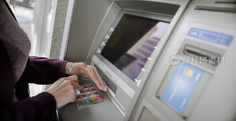 在ATM机输入密码时，女性的手保护键盘