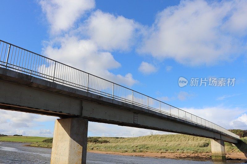 河上的混凝土人行桥，有金属栏杆