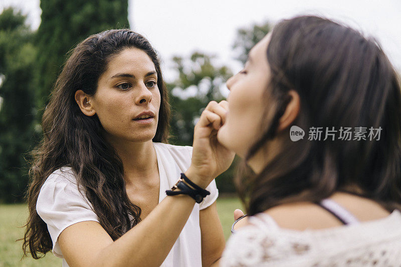 一对年轻女子在公园的户外化妆