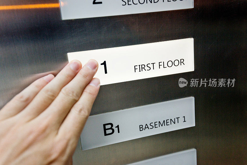 女人在电梯里用手按按钮