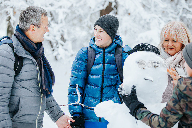 一家人在公园外面玩堆雪人