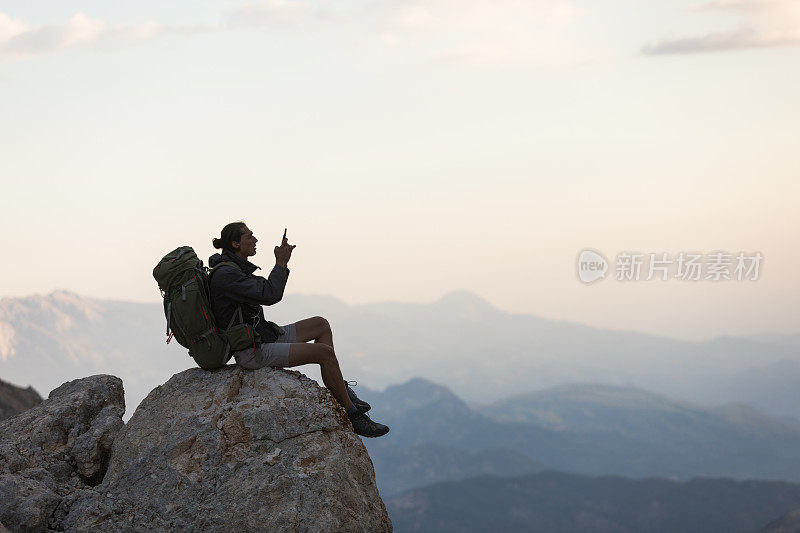 登山者在山顶使用智能手机