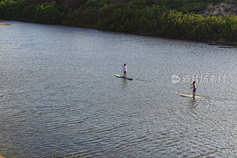 两个年轻人练习站立划桨-水上运动-绿洲-与自然的连接-放松活动-福塔雷萨