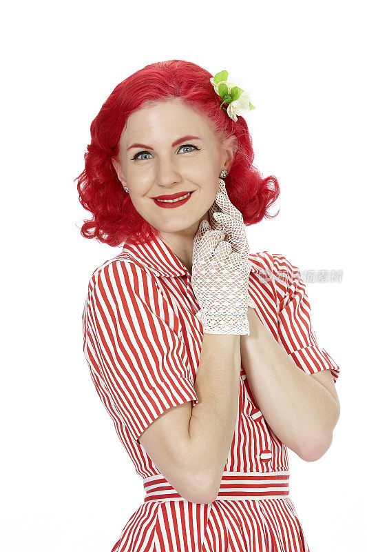 年轻的女人穿着红色的裙子，红头发，微笑着看着镜头